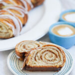 slices of kanelstang Danish cinnamon twist on plate with more of loaf in background behind.