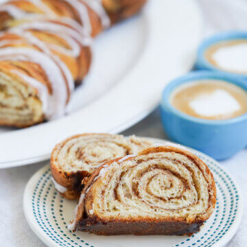 slices of kanelstang Danish cinnamon twist on plate with more of loaf in background behind.