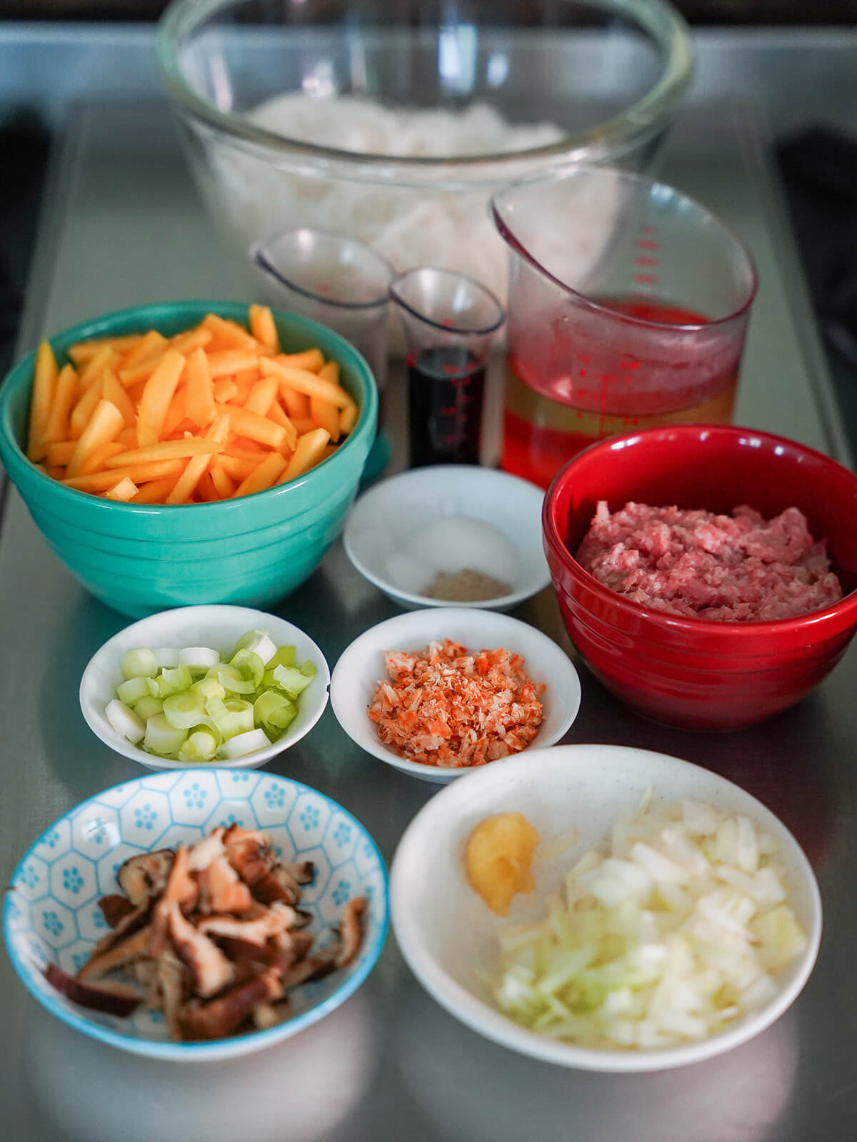prepared ingredients for Taiwanese pumpkin rice vermicelli noodles dishes with chopped vegetables and other ingredients next to stove ready to cook.